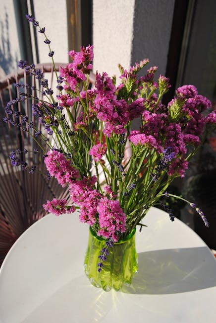 Mezcla vívida de flores rosas y moradas en jarrón verde